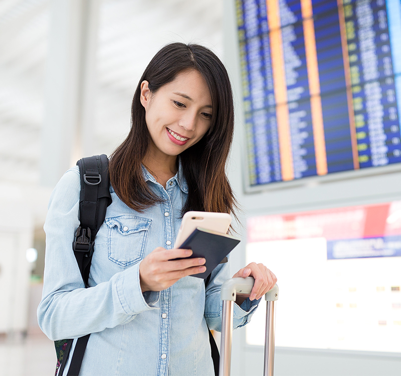 young woman using cellphone in airport ke9nfama.jpg